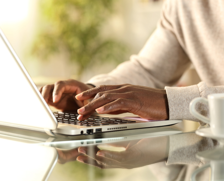 Hands typing on a laptop